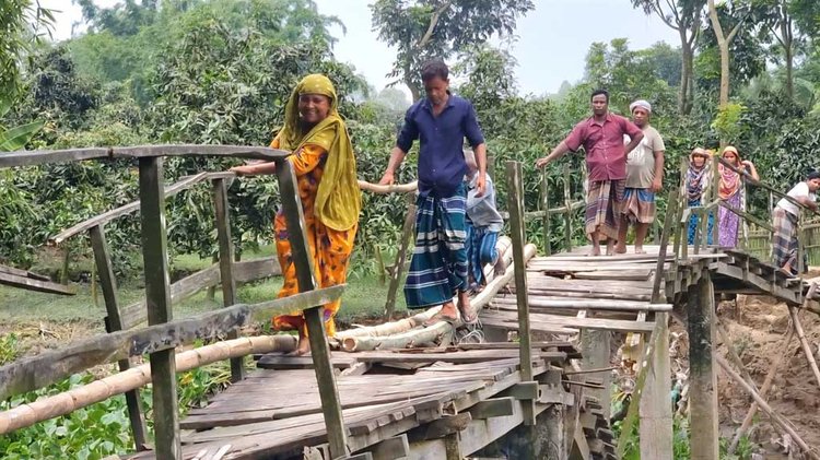 পারাপারের বিকল্প কোনো ব্যবস্থা না থাকায় স্থানীয়রা ঝুঁকি নিয়েই ভাঙা অংশ দিয়ে চলাচল করছেন। ছবি: আজকের পত্রিকা