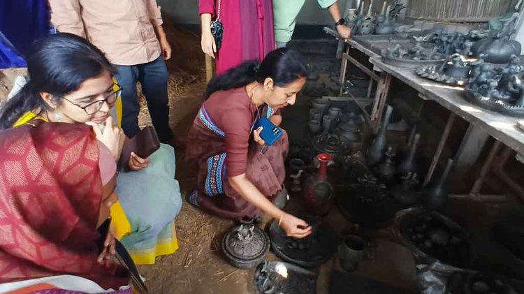 স্থানীয় শিল্পীদের তৈরি পণ্য দেখছেন জেলা প্রশাসক ইশরাত ফারজানা। ছবি: আজকের পত্রিকা