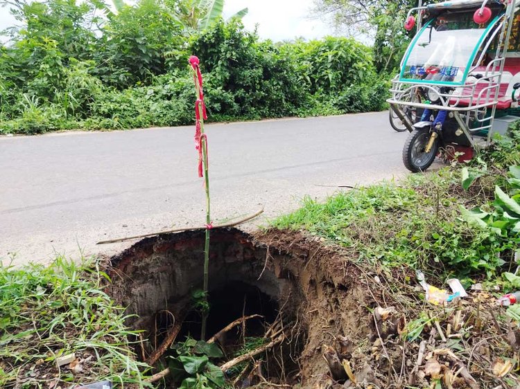 টঙ্গিবাড়ী উপজেলার আলদি-দিঘিরপাড় সড়কের পাশেই বড় একটি গর্ত। একটু অসতর্ক হলেই দুর্ঘটনা ঘটতে পারে। ছবি: আজকের পত্রিকা