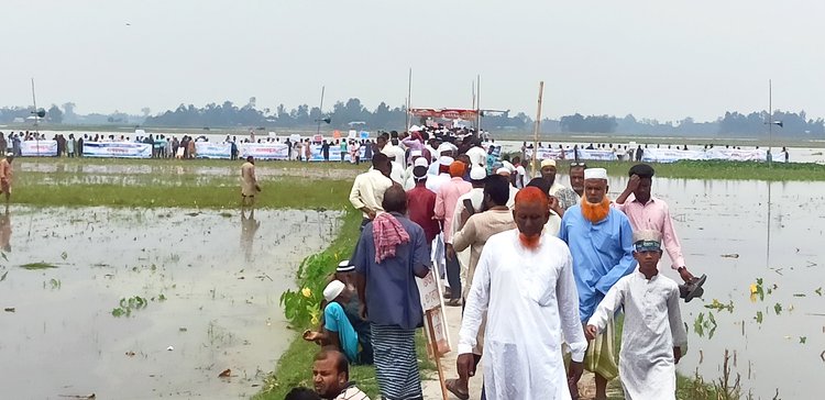 আজ দুপুরে মানববন্ধনে তিস্তার পানিতে নেমে হাজারো মানুষ অংশ নেন এবং দ্রুত মহাপরিকল্পনা বাস্তবায়নের দাবি জানান। ছবি: আজকের পত্রিকা