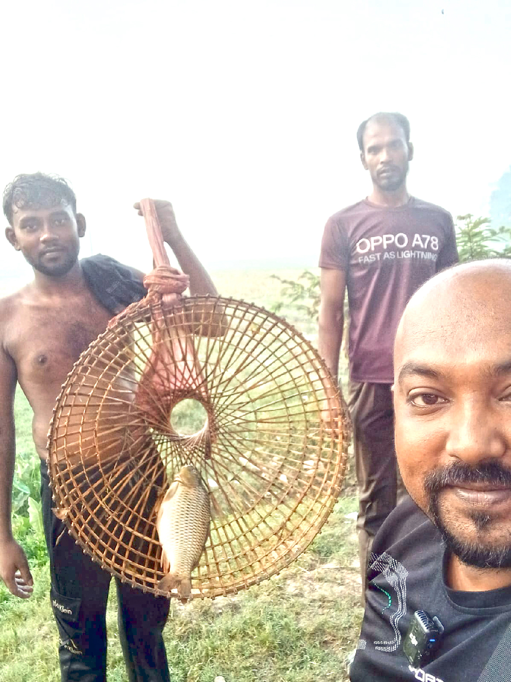 পলোতে মাছ ধরা পড়ায় অনেক খুশি এই যুবক। গতকাল সকালে মানিকগঞ্জের ঘিওর উপজেলার বানিয়াজুরী ইউনিয়নের রাথুরা চক এলাকায়। ছবি: আজকের পত্রিকা