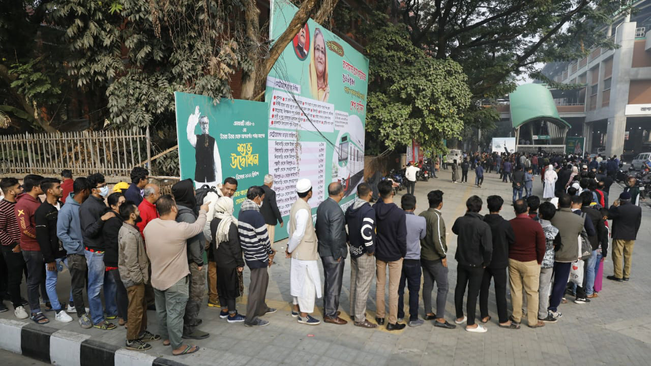 স্টেশনে প্রবেশের জন্য যাত্রীদের দীর্ঘ লাইন।