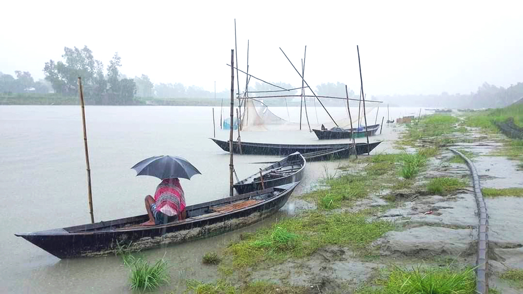 দিনভর টানা বৃষ্টি। মাঝেমধ্যে দেখা মেলে রোদের ঝিলিক। বর্ষার এটাই বৈশিষ্ট্য। জীবিকার তাগিদে বৃষ্টিতে ছাতা মাথায় বেরিয়েছেন এক মাঝি। কালিগঙ্গা নদী, জাবরা, ঘিওর, মানিকগঞ্জ। ২ জুলাই ২০২৩। ছবি: আব্দুর রাজ্জাক