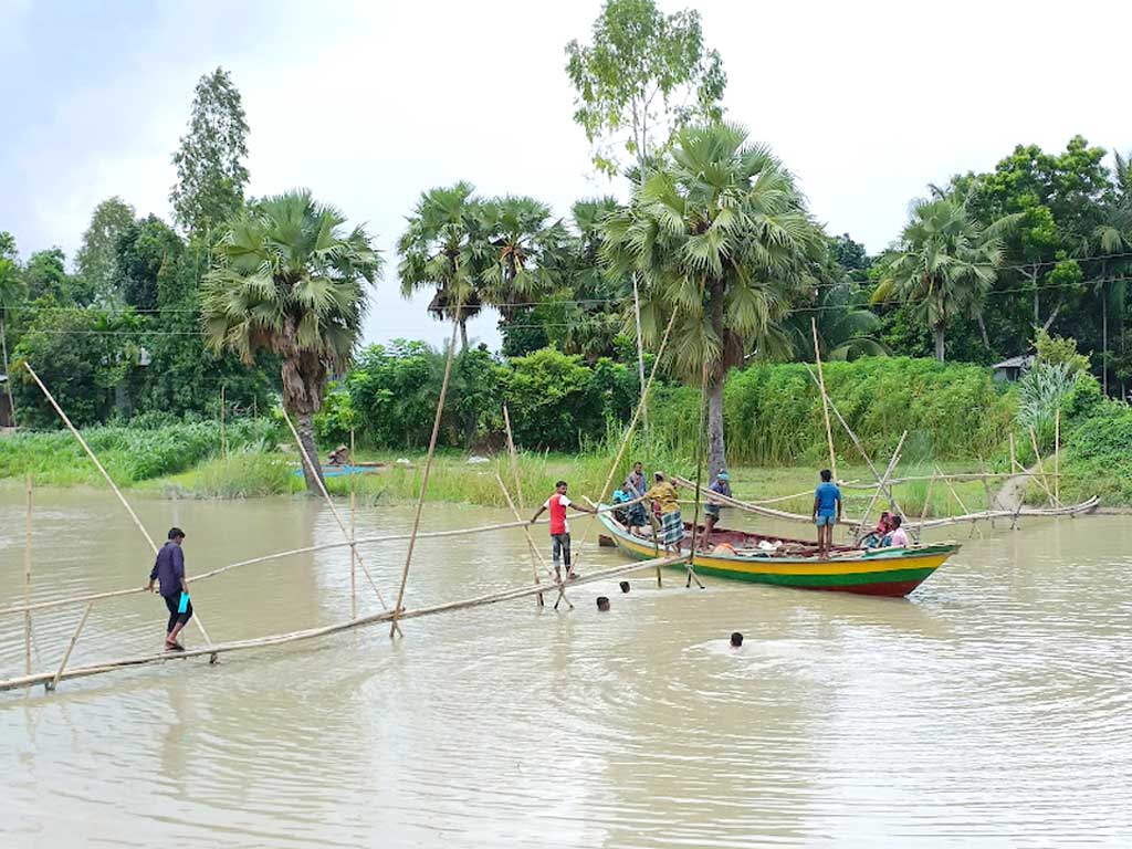 ইছামতী নদীর শাখা খালের ওপর বাঁশের সাঁকো দিয়ে যাতায়াত করেন গ্রামবাসী। এদিকে খালটি দিয়ে চলাচল করে যাত্রী ও পণ্যবাহী ছোট-বড় অসংখ্য নৌকা। পানি বৃদ্ধির ফলে বাঁশের সেতুর নিচ দিয়ে নৌকা যাতায়াতের সময় নৌকার মাঝি-মাল্লারা নেমে সেতুর বাঁশ উঁচু করে ধরতে হয়। এরপর নৌকা পাড় হলে আবার বাঁশ সেতুর যথাস্থানে রেখে দেন। এতে সাঁকোটি ব্যবহার করা এলাকাবাসী ও নৌকার লোকজনের ভোগান্তি হচ্ছে। ঘিওর উপজেলার বড়টিয়া এলাকা, মানিকগঞ্জ, ২২ আগস্ট। ছবি: আব্দুর রাজ্জাক
