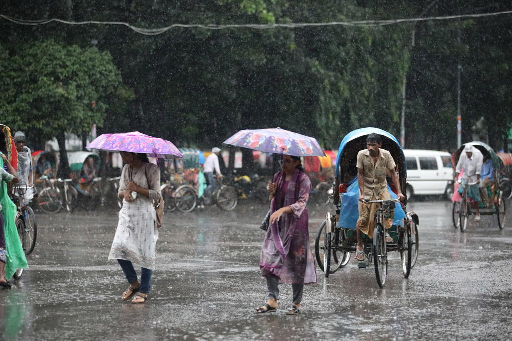 বৃষ্টি উপেক্ষা করে ছাতা মাথায় দুই তরুণীর ঘরে ফেরা।