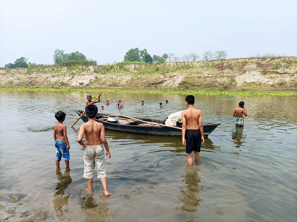 তীব্র গরমে হাপিত্যেশ মানুষসহ প্রাণিকুলের। গ্রীষ্মের তপ্ত দুপুরে একটুখানি স্বস্তি পেতে নদীতে গোসল করছে মানুষ ও গবাদিপশু। একদল শিশুও উচ্ছাসের সঙ্গে ছুটছে নদীতে গোসল করতে। কালীগঙ্গা নদী, সাইংজুরী এলাকা, ঘিওর উপজেলা, মানিকগঞ্জ, ১৯ এপ্রিল, ২০২৪। ছবি: আব্দুর রাজ্জাক 