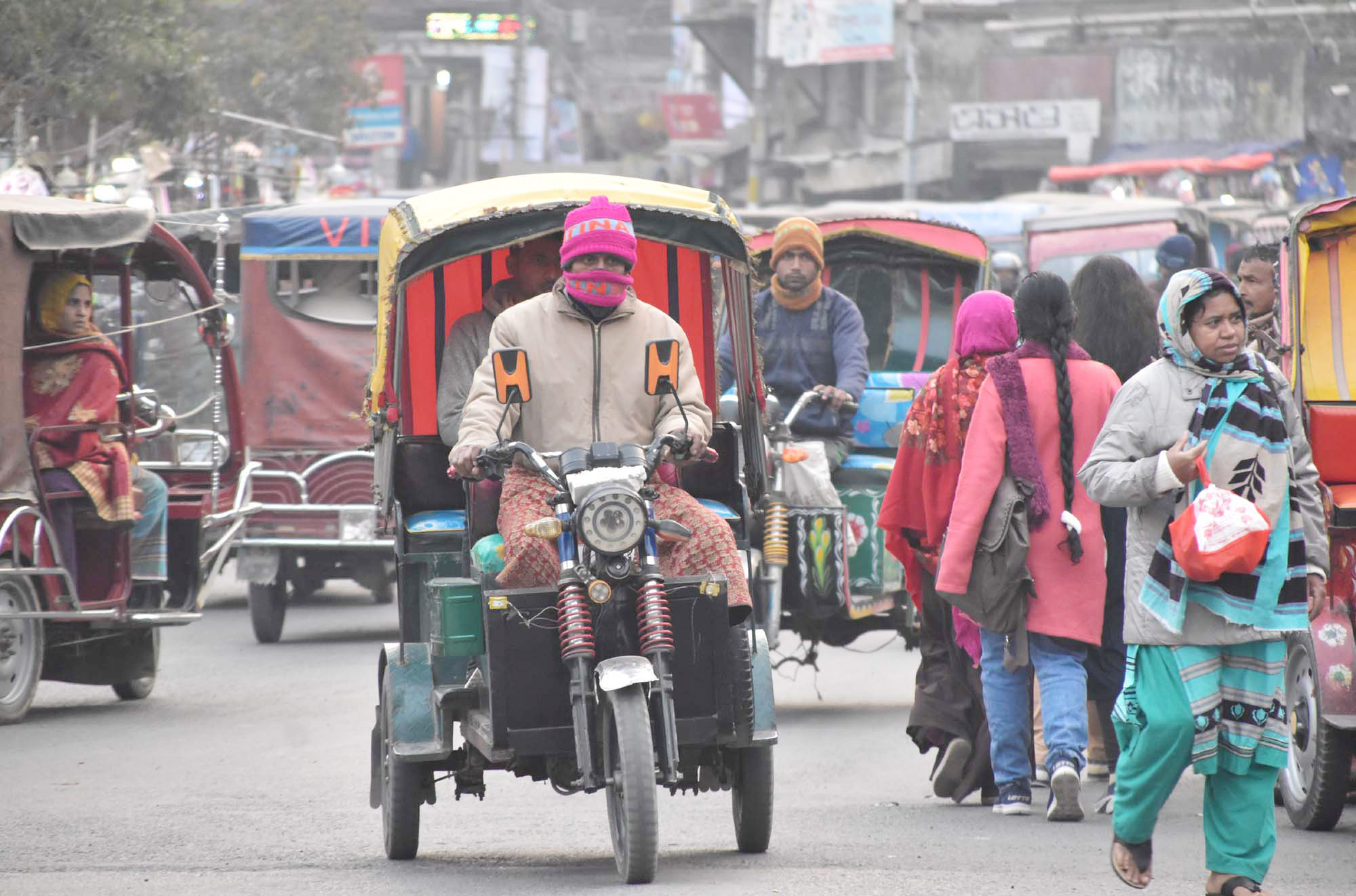রাজশাহীতে কনকনে শীতের গরম পোশাক পড়ে মানুষ বাইরে বের হয়েছে। বেলা নগরী বাটার মোড়, রাজশাহী, ১৯ জানুয়ারি, ২০২৩। ছবি: মিলন শেখ