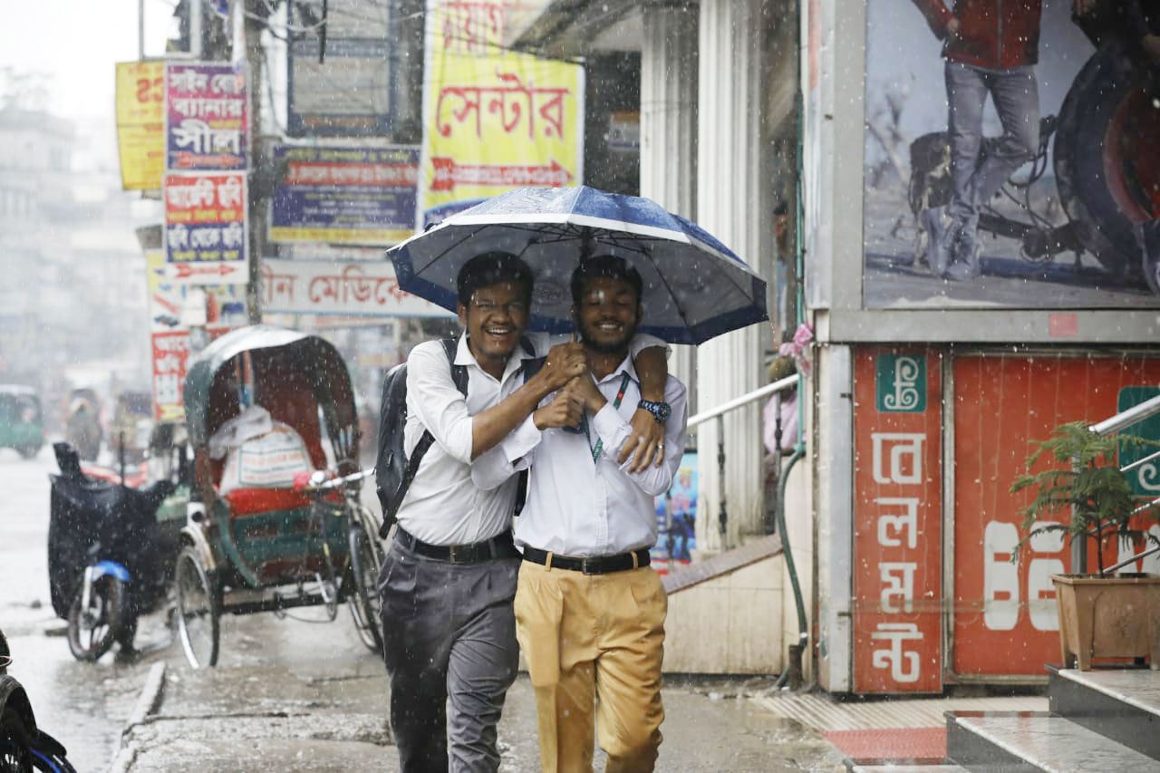 একই ছাতার নিচে খুশিমনে স্কুলের পথে দুই শিক্ষার্থী