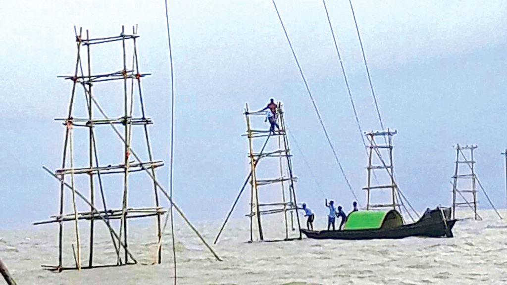 তুফানের দরিয়ায় বাঁশের টাওয়ারে ঝুলছে ১১ হাজার ভোল্টের তার