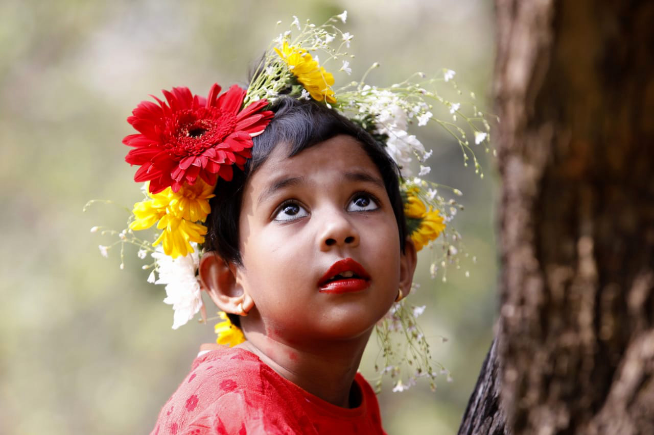 ফুলের মুকুট পরে আছে ছোট এক শিশু। 