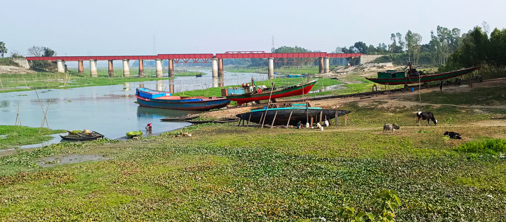 এক মাঝি কাঠ মিস্ত্রিসহ কয়েকজনকে নিয়ে ভাঙা নৌকা মেরামত করছেন। পাশে ডক ইয়ার্ডেও কাজ চলছে। রায়পুরার মুছাপুর ইউনিয়নের বীরশ্রেষ্ঠ মতিউর নগর গ্রামের পাশ দিয়ে বয়ে চলা পুরাতন ব্রহ্মপুত্রের শাখা নদের পাড়, নরসিংদী, ১৮ ফেব্রুয়ারি ২০২৪। ছবি: হারুনূর রশিদ
