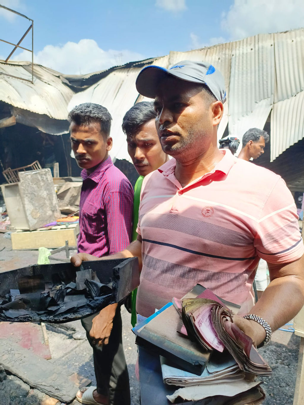 গতকাল বৃহস্পতিবার ভোরে রাজধানীর মোহাম্মদপুরের কৃষি মার্কেটে আগুনে কয়েক শ দোকান পুড়ে গেছে। গতকাল ভোর ৩টা ৪১ মিনিটে সেখানে আগুন লাগে। ফায়ার সার্ভিসের ১৭টি ইউনিটের চেষ্টায় সকাল ৯টা ২৫ মিনিটে আগুন নিয়ন্ত্রণে আসে। আগুনে পুড়ে যাওয়া টাকা হাতে এক ব্যবসায়ী। ১৫ সেপ্টেম্বর ২০২৩। ছবি: জাহিদুল ইসলাম