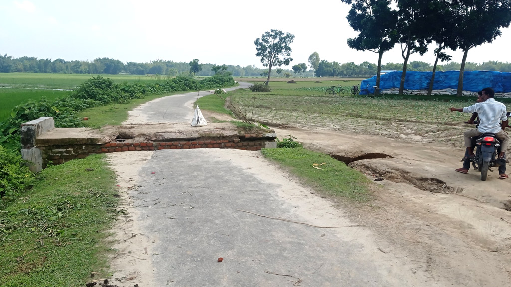 স্রোতে সংযোগ সড়কে ধস ধানখেত দিয়ে চলাচল