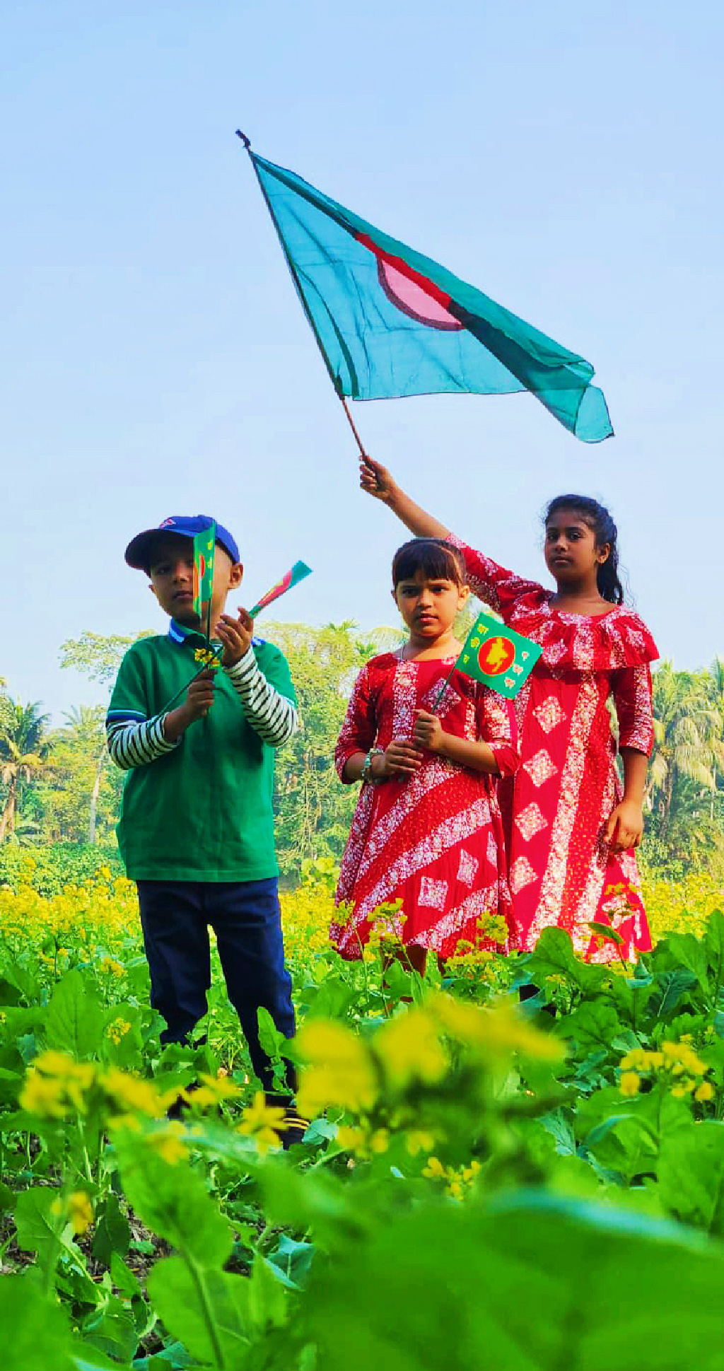 মহান বিজয় দিবস উপলক্ষে শিশুদের বায়না থাকে পতাকা কেনার। অভিভাবকদের কিনে দেওয়া পতাকা হাতে ফসলের মাঠে তারা মেতে উঠেছে দুরন্তপনায়। ঢাকা-আরিচা মহাসড়ক সংলগ্ন ঘিওর উপজেলার বানিয়াজুরী ইউনিয়নের রাথুরা গ্রামের ফসলের মাঠ থেকে তোলা, মানিকগঞ্জ, ১৬ ডিসেম্বর ২০২৪। ছবি: আব্দুর রাজ্জাক