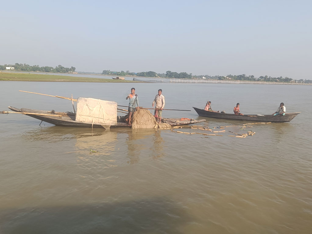 মেঘনা নদীতে পাশাপাশি দুই নৌকা। একটি নৌকায় বৃদ্ধসহ বসে আছে দুই শিশু। এর মধ্যে এক শিশু দাঁড় বাইছে। সামনের সারিতে থাকা নৌকায় জাল টানছেন দুই জেলে। ষাটবাড়িয়া গ্রাম, সরাইল উপজেলা, ব্রাহ্মণবাড়িয়া, ৩০ অক্টোবর। ছবি: এম মনসুর আলী 