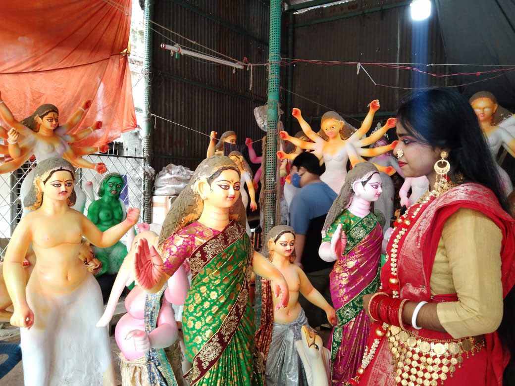 শাড়ি পরান শেষে প্রতিমা দেখছেন এক হিন্দু ধর্মাবলম্বী।