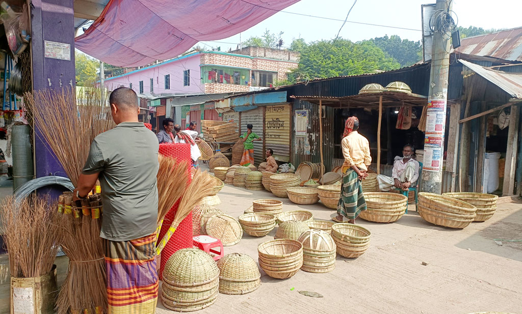 মানিকগঞ্জে গৃহস্থালির কাজে প্লাস্টিক সামগ্রীর চাহিদা বৃদ্ধি পেলেও এখনো বাঁশের তৈরি জিনিসের কদর কমেনি। জেলার সাপ্তাহিক হাট-বাজারগুলোতে পরিমাণে কম হলেও এগুলো বিক্রি হচ্ছে। বিশেষ করে কুলা, ডালা, চাটাই, মাথাইল, পলো, মোড়া, ডুলি, হাতপাখার মতো বাঁশের সামগ্রীর ভালো চাহিদা আছে। সাটুরিয়া হাট থেকে তোলা, ২৬ নভেম্বর ২০২৪। ছবি: আব্দুর রাজ্জাক