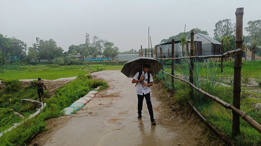 ঘূর্ণিঝড় রিমালের প্রভাবে সকাল থেকে ঝোড়ো হাওয়ার সঙ্গে শুরু হয় বৃষ্টি। এই বৈরী আবহাওয়ায় ছাতা নিয়ে স্কুলে যাচ্ছে এক শিশু। সরাইল উপজেলার বরইচারা এলাকা থেকে তোলা, ব্রাহ্মণবাড়িয়া, ২৭ মে ২০২৪। মো. মনসুর আলী