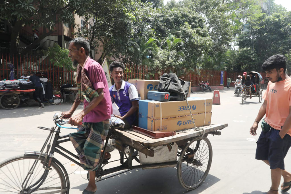 এসি কিনে নিয়ে হাসিমুখে ফিরছেন যুবক।