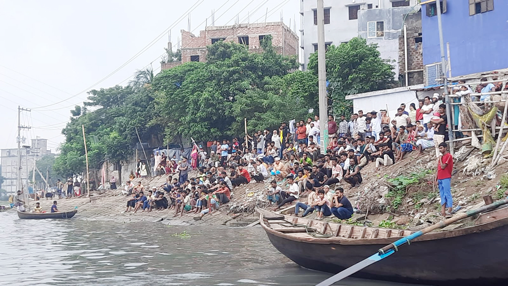 উদ্ধার অভিযান দেখতে বুড়িগঙ্গার তীরে বসে উৎসুক মানুষজন। 