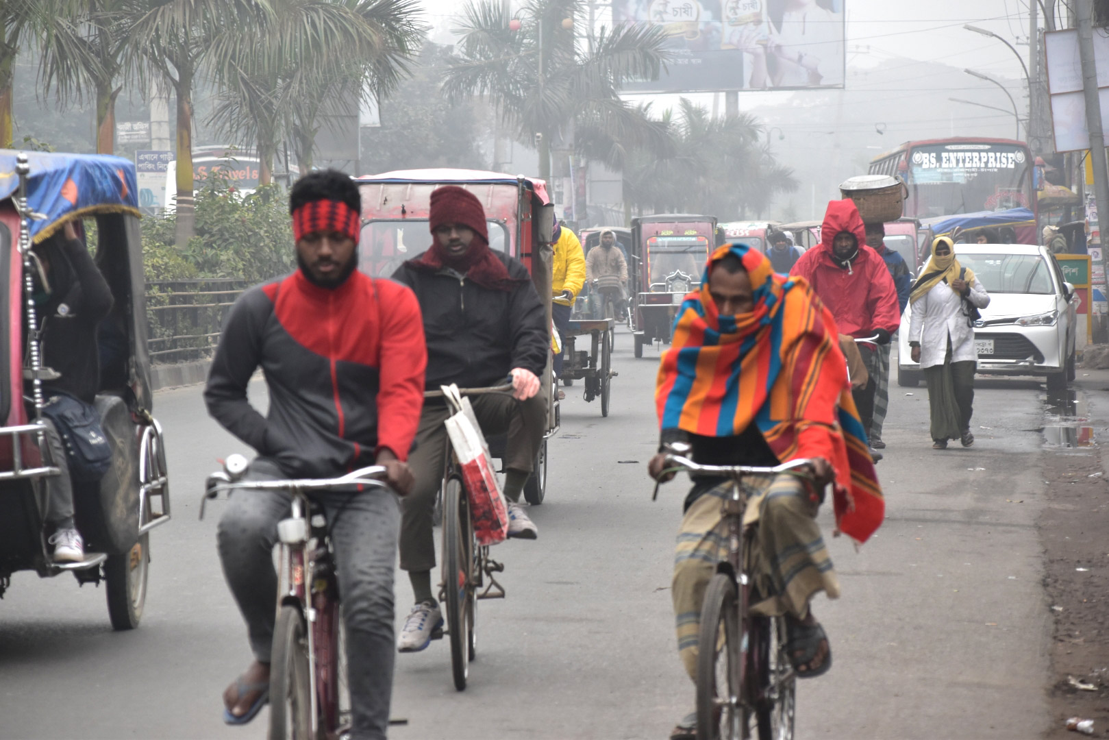 কুয়াশায় ঢাকা সকালে সাধারণ মানুষ নিজ নিজ কাজে ছুটছে। বাস টার্মিনাল এলাকা, রাজশাহী, ৩ জানুয়ারি ২০২৩। ছবি: মিলন শেখ 