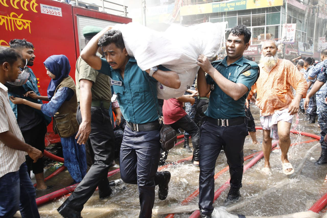 ব্যবসায়ীদের মালামাল নিরাপদ স্থানে সরিয়ে নিচ্ছেন পুলিশ সদস্যরা