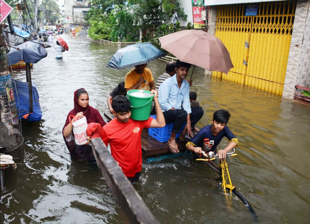 কয়েক দিনের টানা বৃষ্টি ও জোয়ারের কারণে কোমর সমান পানিতে যাতায়াত করতে হচ্ছে নগরবাসীকে। আজ চট্টগ্রাম নগরীর চকবাজার কাঁচা বাজার মোড় এলাকায়। ছবি: হেলাল সিকদার