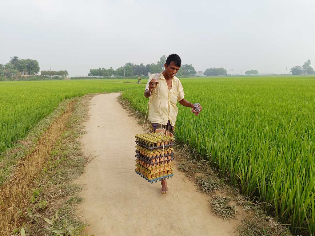 মাছ, মাংসের দামের ঊর্ধ্বগতির কারণে গ্রামের সাধারণ মানুষের কাছে এখন ডিমের চাহিদা বেশি। এই ডিম বিক্রেতা ভারে করে ডিম নিয়ে গ্রামে গ্রামে বিক্রি করেন। সরাইল উপজেলার বরইচারা এলাকা, ব্রাহ্মণবাড়িয়া, ১৩ মার্চ ২০২৪। ছবি: এম মনসুর আলী