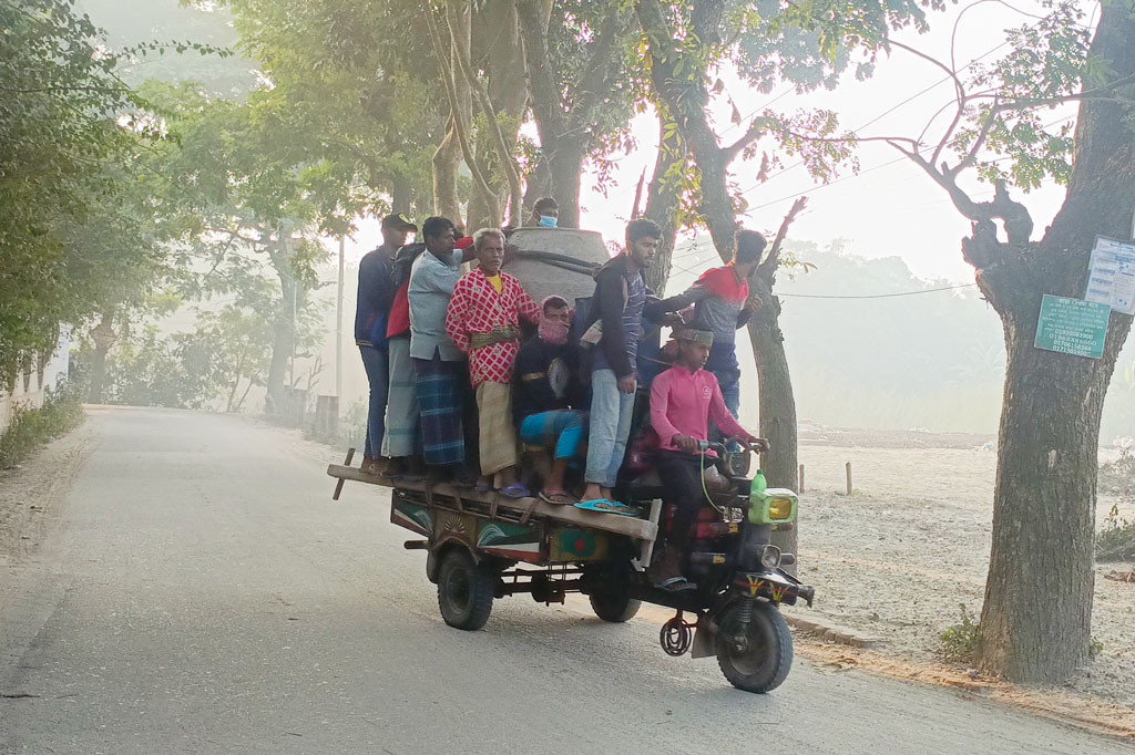 হালকা কুয়াশা শীতের আগমনী সংকেত দিচ্ছে। কিছুটা শীতও পড়তে শুরু করেছে। জীবিকার তাগিদে ঢালাই মেশিনেই ঝুলে ঝুঁকি নিয়ে গন্তব্যে যাচ্ছেন শ্রমিকেরা। রায়পুরার পৌর এলাকার থেকে তোলা, নরসিংদী, ২৬ নভেম্বর ২০২৪। ছবি: হারুনূর রশিদ