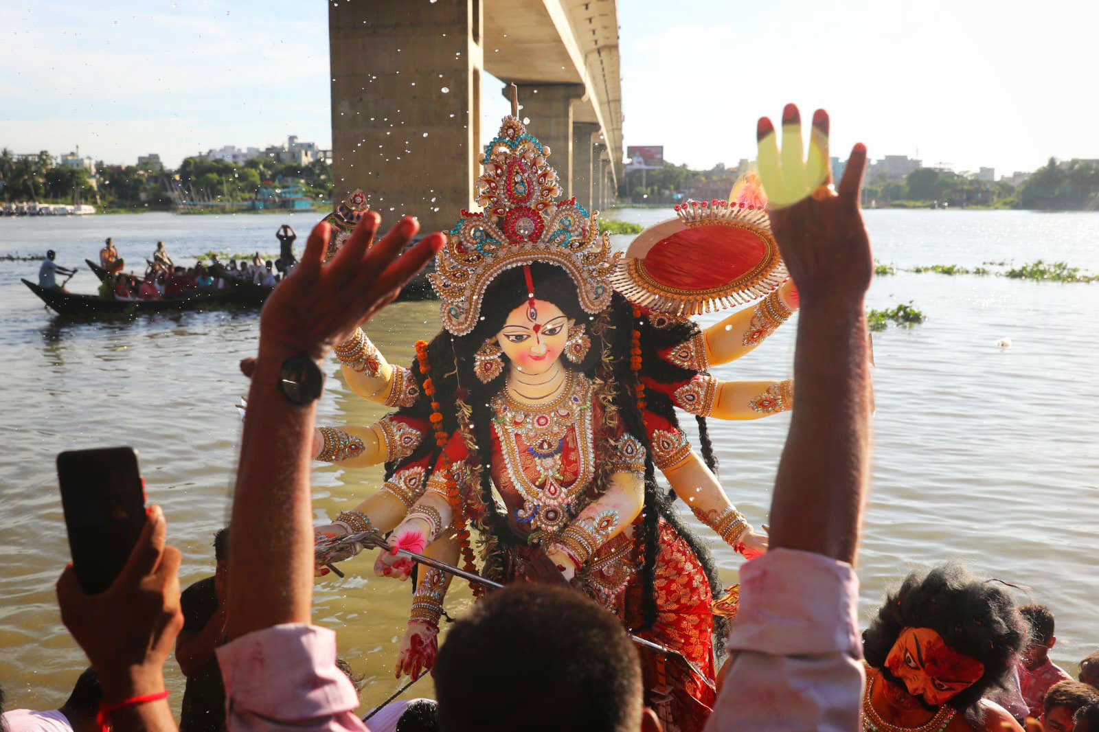 ঢাকঢোল বাজিয়ে দুর্গা মাকে বিসর্জনের জন্য ঘাটে নিয়ে এসেছেন ভক্তরা। এ বছরের জন্য ভক্তরা বিদায় দিচ্ছেন দুর্গা মাকে। বছিলা, মোহাম্মদপুর, ঢাকা, ৫ অক্টোবর, ২০২২। ছবি: সজল