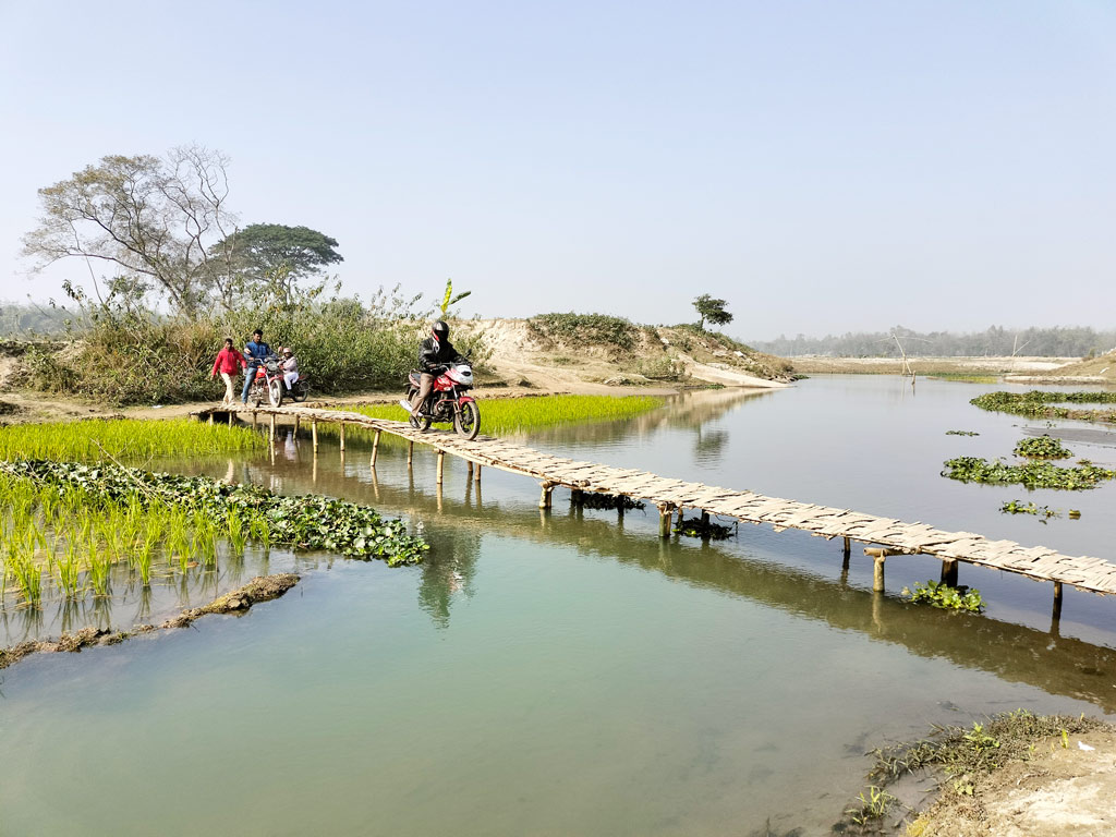 আলমবিদিতর ইউনিয়নের পাইকান কুটিপাড়ায় ঘাগট নদীর ওপর নির্মিত বাঁশের সাঁকো দিয়ে এভাবেই ঝুঁকি নিয়ে পারাপার হচ্ছেন পথচারী। পাইকান কুটিপাড়া, গঙ্গাচড়া, রংপুর, ২৭ জানুয়ারি ২০২৩। ছবি: আবদুর রহিম
