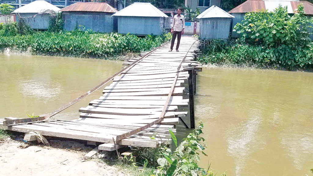 নড়বড়ে কাঠের সেতু, খুলে গেছে তক্তা, লোহার খুঁটি