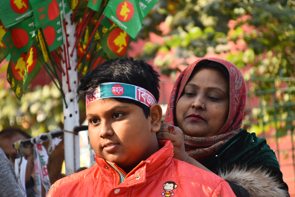 মহান বিজয় দিবস উপলক্ষে মাথায় ব্যান্ডেনা পড়ছে এক শিশু। রাজশাহী কলেজ চত্বর থেকে তোলা, ১৬ ডিসেম্বর ২০২৪। ছবি: মিলন শেখ