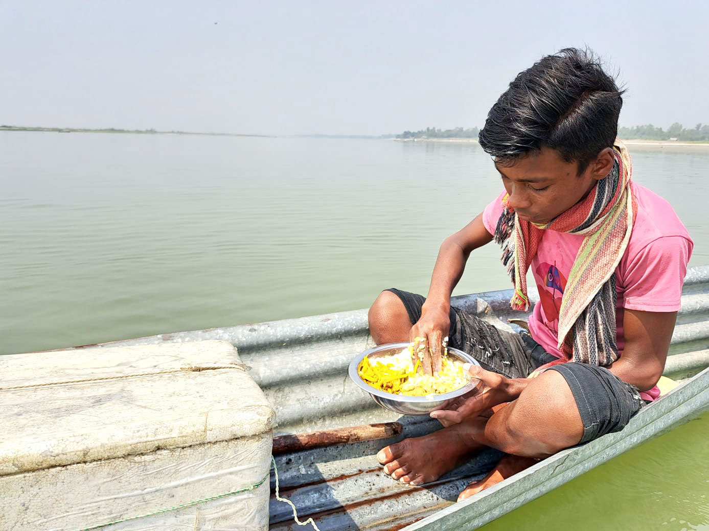 সোহেল রানা স্থানীয় একটি বিদ্যালয়ের ষষ্ঠ শ্রেণির শিক্ষার্থী। সংসারে স্বচ্ছতা ফেরাতে স্কুল বন্ধের দিন টিন ও কাঠ দিয়ে তৈরি ছোট ঠোঙা (নৌকা) দিয়ে পদ্মা নদীতে মাছ ধরে। দুপুরে নদীতে জাল ফেলে ঠোঙাতেই খাবার খায়। পদ্মা নদী, মিতারা, টঙ্গিবাড়ী, মুন্সিগঞ্জ। ৫ মার্চ, ২০২৩। ছবি: রিয়াদ হোসাইন