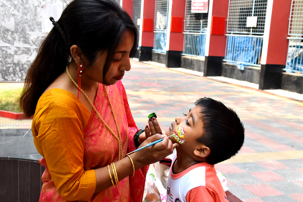 বাংলা ১৪৩১ সাল বরণ উপলক্ষে শিশুর গালে আলপনা আঁকছেন এক নারী। আজ সকালে রাজশাহী কলেজ চত্বর, রাজশাহী, ১৪ এপ্রিল ২০২৪। ছবি: মিলন শেখ