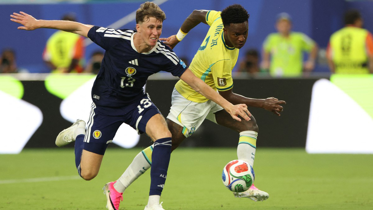 স্কটল্যান্ডের ডিফেন্ডার জ্যাক হেনড্রির কাছ থেকে বল কেড়ে নিয়ে গোল করেছিলেন ভিনিসিয়ুস জুনিয়র। তবে ভিডিও অ্যাসিস্ট্যান্ট রেফারির (ভিএআর) মাধ্যমে দেখার পর সেটা বাতিল করা হয়েছে। এ কারণেই হ্যাটট্রিকটা হয়নি। বাতিল হওয়ার আগে ৭ মিনিটে গোল করেছিলেন ভিনি। এরপর যোগ করা সময়ের তিন মিনিটে নিজের দ্বিতীয় গোল করেন তিনি। ছবি: এএফপি