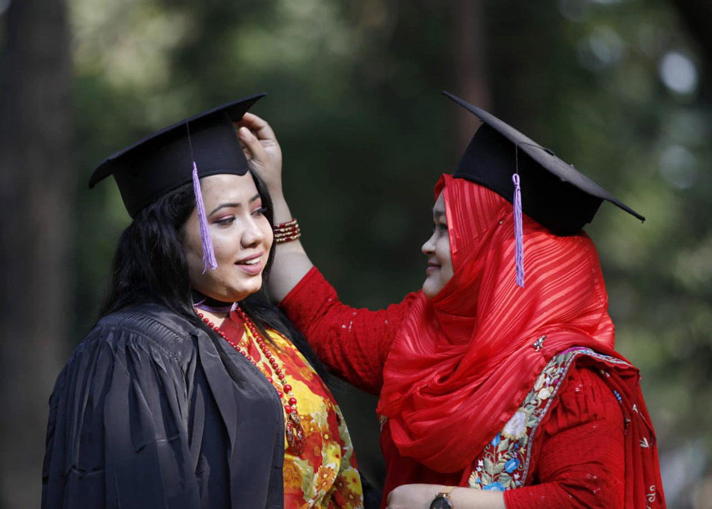 সমাবর্তন নিতে আসা বান্ধবীর টুপি ঠিক করে দিচ্ছেন অপর বান্ধবী। 