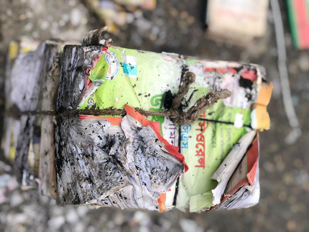 আগুনে পুড়ে যাওয়া কিছু বই। দড়ি দিয়ে বেঁধে রাখার কারণে পুরোপুরি পুড়ে যায়নি