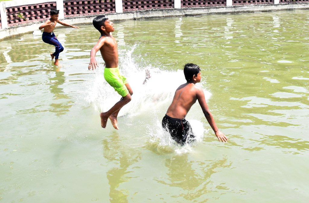 রাজশাহীর ওপর দিয়ে বয়ে যাচ্ছে মাঝারি তাপপ্রবাহ। ভ্যাপসা গরমে নাভিশ্বাস। গরমে থেকে স্বস্তি পেতে পুকুরে লাফালাফি ও সাঁতার কাটছে শিশু-কিশোরেরা। রাজশাহী বিশ্ববিদ্যালয়ে একটি পুকুরে, ৫ এপ্রিল, ২০২৪। ছবি: মিলন শেখ