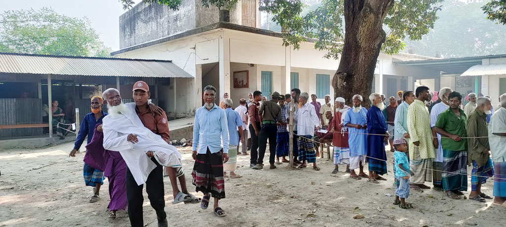 দিনাজপুরের বিরল উপজেলার তিনটি ইউনিয়ন পরিষদে চলছে ভোটগ্রহণ। শতবর্ষী ইয়াকুব আলী নাতির সঙ্গে এসেছেন নির্বাচনে ভোট দিতে। ভোটদান শেষে এক আনসার সদস্যের কোলে চড়ে বের হয়ে আসেন তিনি। বিরল উপজেলার বুনিয়াদপুর সিনিয়র মাদ্রাসা ভোটকেন্দ্র, দিনাজপুর, ২৮ এপ্রিল ২০২৪। ছবি: মো. আনিসুল হক