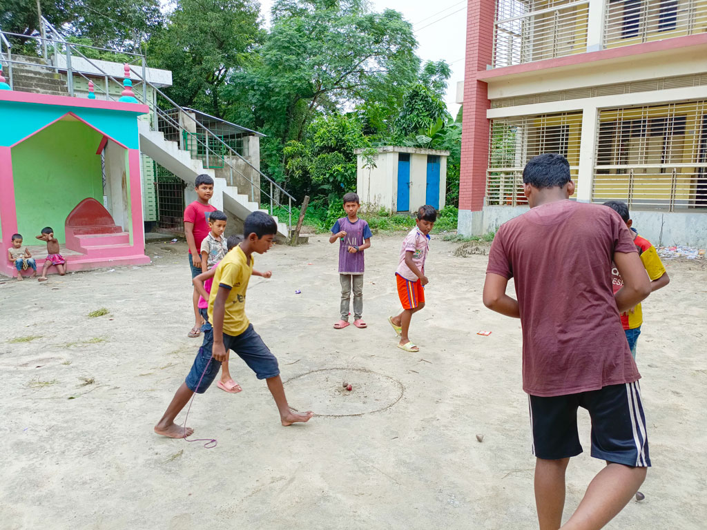 সময়টাই দুরন্তপনার, খেলাধুলার। স্কুলের মাঠে লাটিম নিয়ে খেলায় মেতে থাকতে দেখা যায় কয়েক জন বালককে। রায়পুরা উপজেলার মুছাপুরের পূর্বহরিপুর সরকারি প্রাথমিক বিদ্যালয়, নরসিংদী, ২৫ সেপ্টেম্বর ২০২৩। ছবি: হারুনূর রশিদ