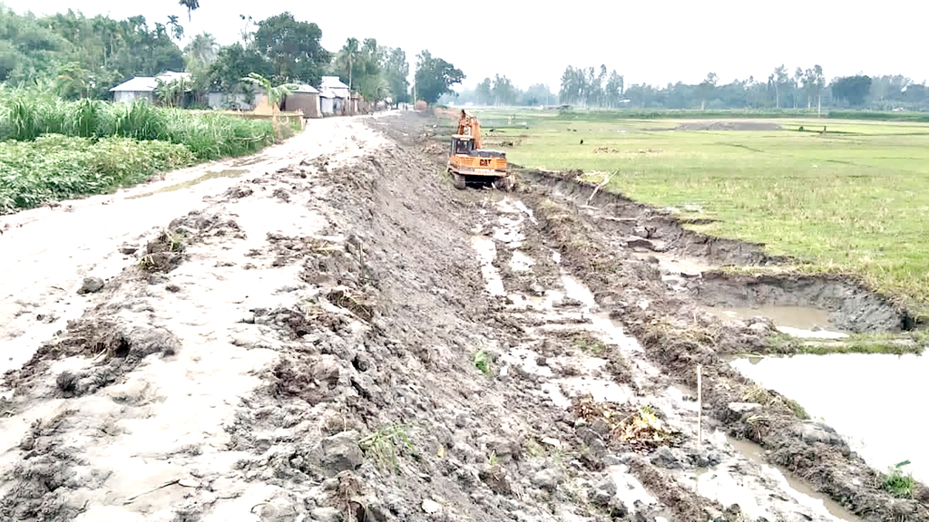 ফসলি খেতে গর্ত খুঁড়ে পাশের সড়ক সংস্কার