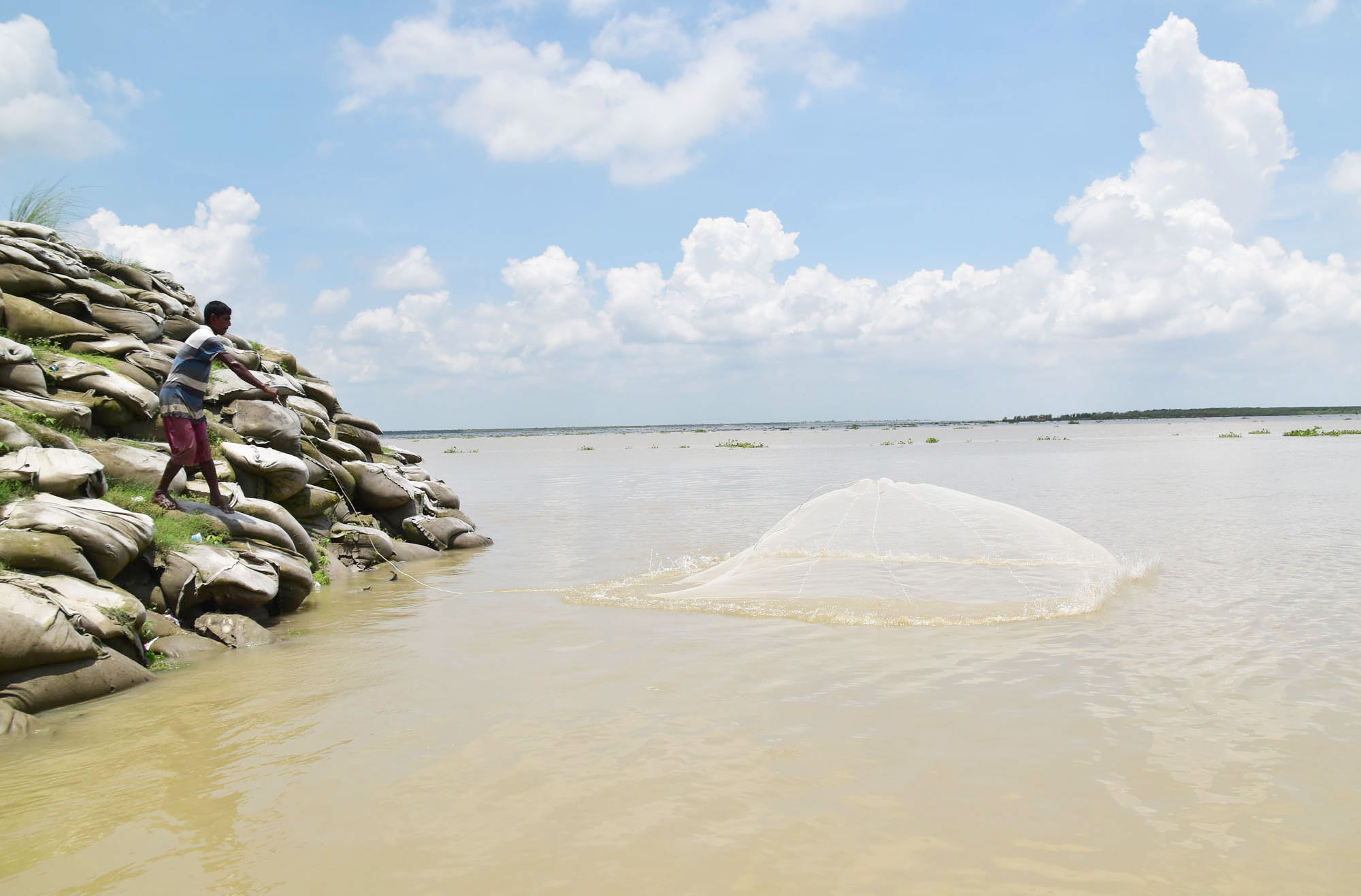 রাজশাহীতে পদ্মা নদীর পানি বাড়ছে। সারা রাত নদীতে নৌকা নিয়ে ভেসে ভেসে মাছ শিকার করেছেন জেলেরা। কেউ আবার কাকডাকা ভোরে মুঠোজাল হাতে, চলে গেছেন নদীর পাড়ে মাছ শিকার করতে। টি-বাঁধ, রাজশাহী, ৬ জুলাই ২০২৩। ছবি: মিলন শেখ