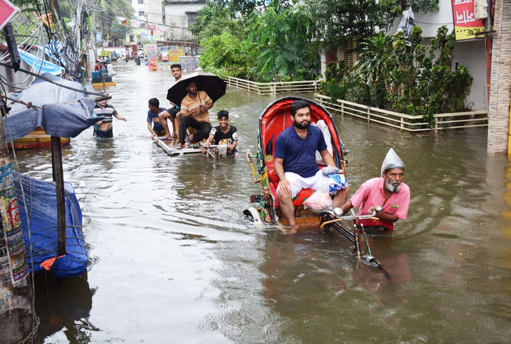 কয়েক দিনের টানা বৃষ্টি ও জোয়ারের কারণে কোমর সমান পানিতে যাতায়াত করতে হচ্ছে নগরবাসীকে। আজ চট্টগ্রাম নগরীর চকবাজার কাঁচা বাজার মোড় এলাকায়। ছবি: হেলাল সিকদার