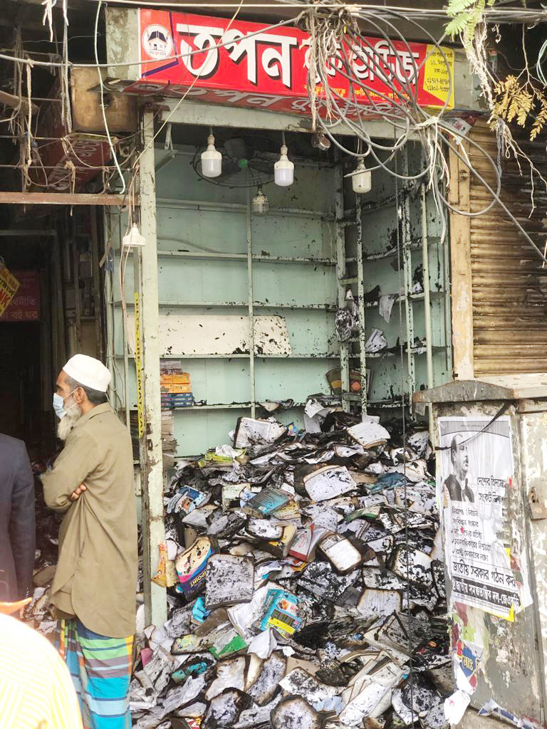 আগুনে পুড়ে যাওয়া বইয়ের দোকানে পুড়ে যাওয়া বইয়ের স্তূপ