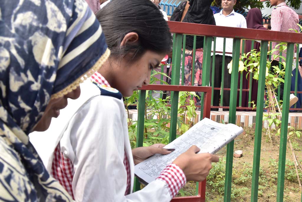 এইচএসসি ও সমমানের পরীক্ষা শুরু হচ্ছে আজ বাংলা পরীক্ষার মাধ্যমে। এক পরীক্ষার্থীকে কেন্দ্রের সামনে বসে শেষ সময়ের প্রস্তুতি নিতে দেখা যাচ্ছে। নগরের শাহ্ মখদুম কলেজ, রাজশাহী, ১৭ আগস্ট। ছবি: মিলন শেখ
