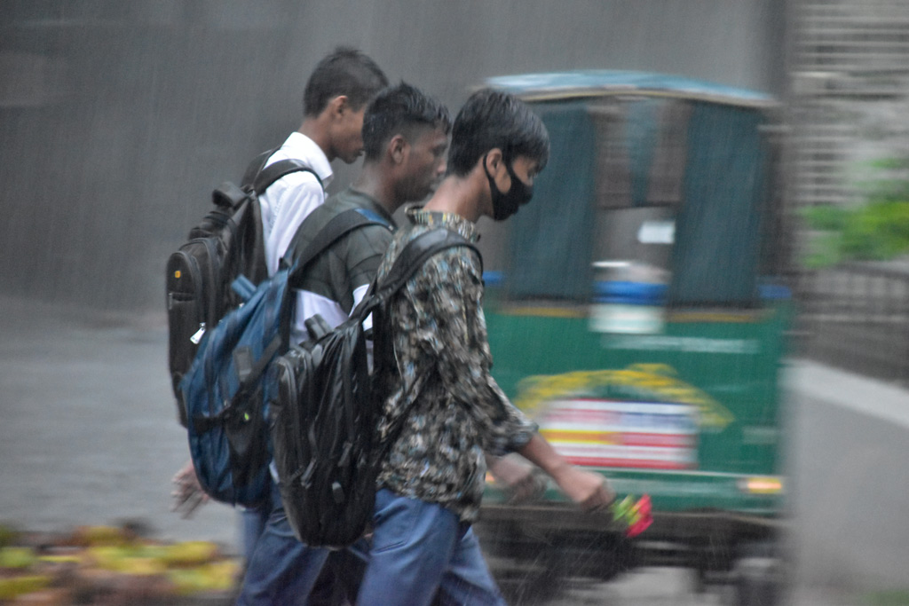 রাজশাহীতে বেলা তিনটার পর থেকে অঝোর বৃষ্টিতে তলিয়ে গেছে নগরীর পথঘাট। বৃষ্টিতে ভিজে বাড়ি ফিরছে স্কুল-কলেজের শিক্ষার্থীরা। নিউমার্কেট এলাকা, রাজশাহী, ২৪ সেপ্টেম্বর ২০২৩। ছবি: মিলন শেখ।