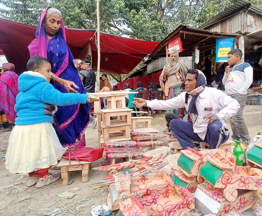 গ্রামীণ মেলায় দাদির সঙ্গে শখের খেলনা কিনতে এসেছে এক শিশু। প্রায় দুই শ বছরের ঐতিহ্যবাহী এই মেলা মাঘ মাসের প্রথম দিন অনুষ্ঠিত হয়ে আসছে। কালাচাঁদপুর গ্রাম, বালিয়াখোড়া ইউনিয়ন, ঘিওর উপজেলা, মানিকগঞ্জ, ১৬ জানুয়ারি, ২০২৪। ছবি: আব্দুর রাজ্জাক