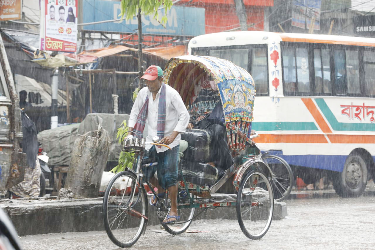 ভিজে ভিজে যাত্রী টানছেন রিকশাচালক। 