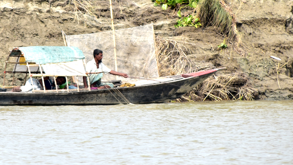 নৌকায় বসে নদীর স্রোতের দিকে মাছের টোপ ফেলে ছিপ নিয়ে মাছ ধরছেন এক জেলে। নগরীর ফুদকিপাড়া এলাকার পদ্মা নদী, ২৫ অক্টোবর ২০২৩ । ছবি: মিলন শেখ